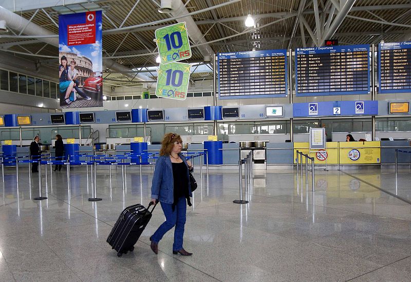Una pasajera atraviesa el solitario aeropuerto de Atenas, donde los trabajadores han parado durante cuatro horas