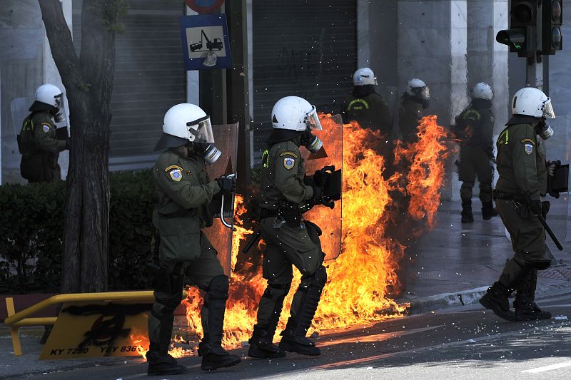 Agentes de policía ante uno de los fuegos provocados por los cócteles molotov lanzados por los manifestantes