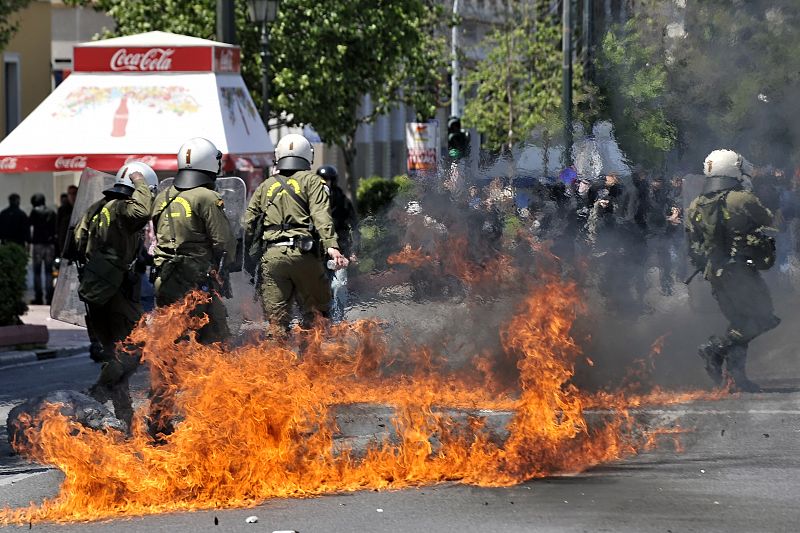 Varios agentes tras las llamas provocadas por cócteles molotov lanzados por un grupo de manifestantes