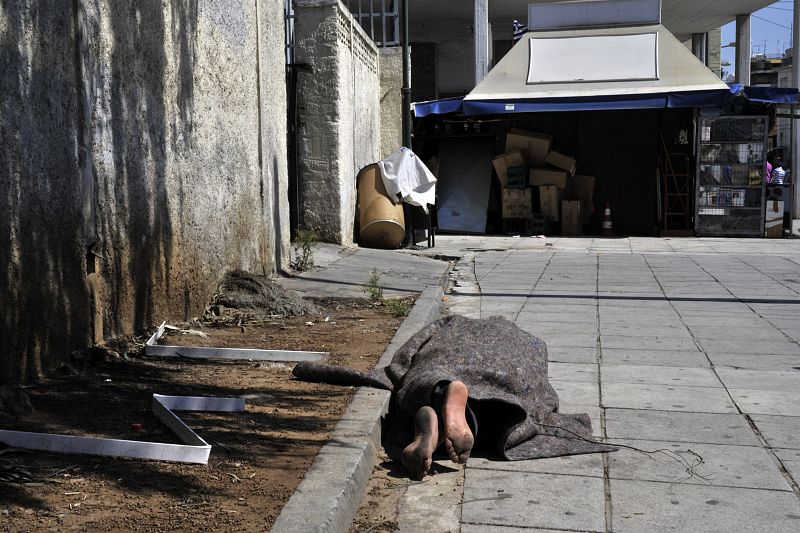 Un indigente duerme en el exterior de la principal estación de tren de Atenas