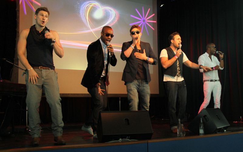 Los integrantes del grupo de Blue, de izquierda a derecha: Lee Ryan, Simon Webbe, Duncan James y Antony Costa. Junto a ellos, uno de sus coristas.