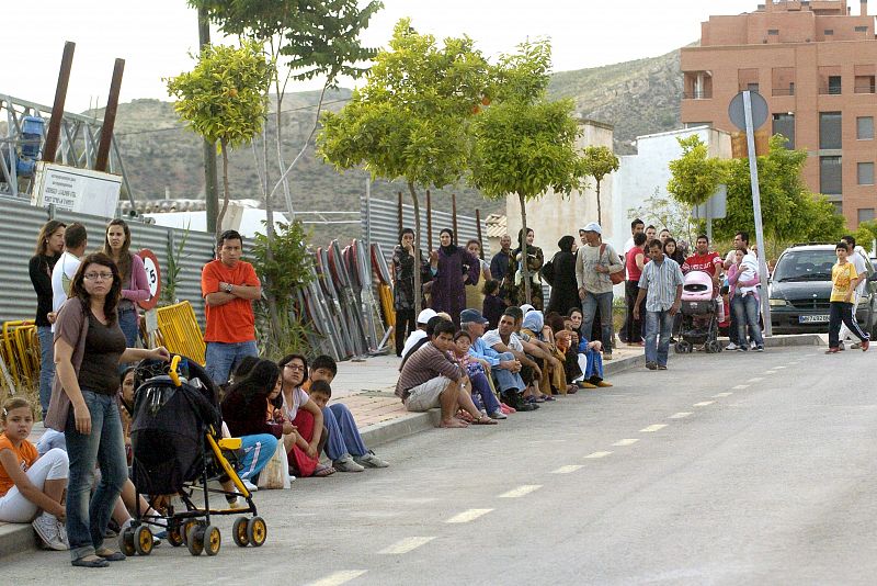 Varias personas esperan sentadas en el barrio de San Diego de Lorca.
