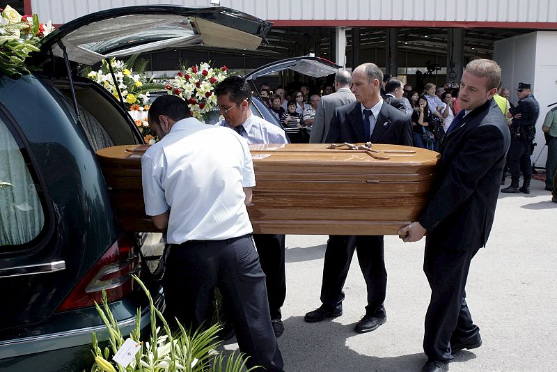 Los féretros son trasladados a los coches fúnebres tras celebrarse hoy el funeral