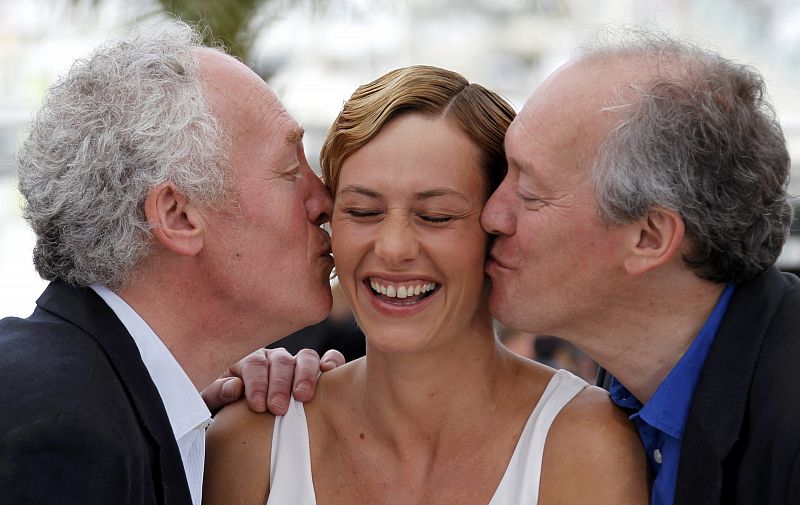 Directors Jean-Pierre and Luc Dardenne kiss actress De France during a photocall for the film Le Gamin au velo" in competition at the 64th Cannes Film Festival