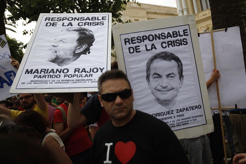 Demonstrators hold pictures of Spain's PM Jose Luis Rodriguez Zapatero and Popular Party leader Mariano Rajoy during a demonstration in Malaga