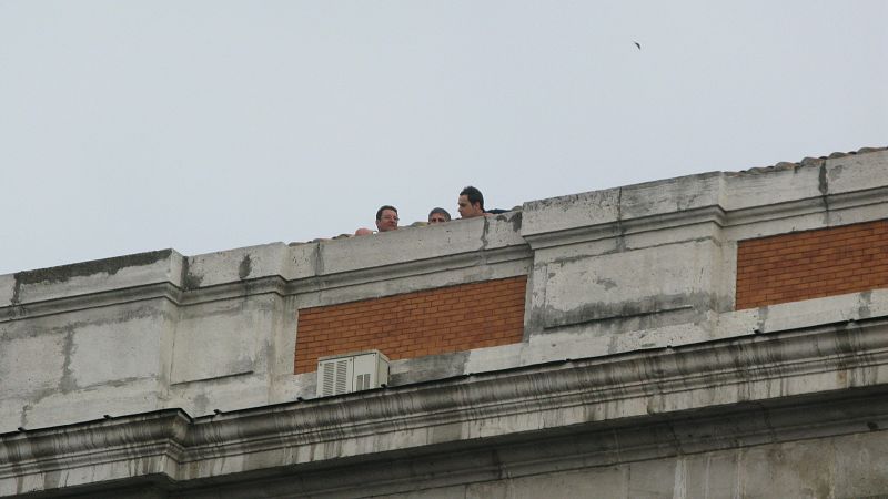 Tres personas siguen las movilizaciones desde la azotea de la Real Casa de Correos, en la que estTres personas siguen las movilizaciones desde la azotea de la Real Casa de Correos, en la que está ubicada la Presidencia de la Comunidad de Madrid.