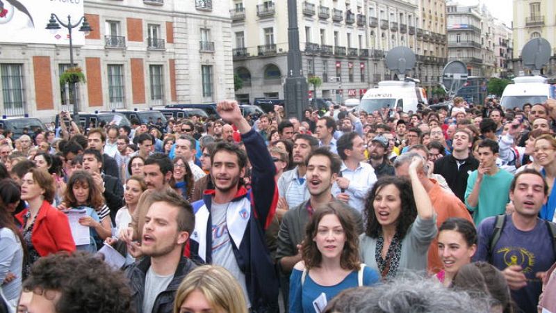 En la imagen, al fondo, pueden observarse seis furgonetas de la Policía Nacional, parte del amplio despliegue de seguridad puesto en marcha para la concentración.