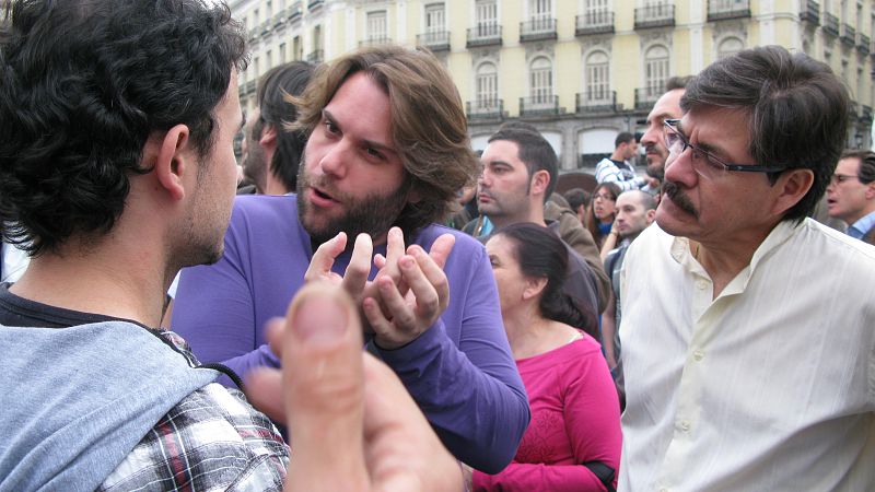 Carlos Paredes, portavoz de Democracia real ya, -izda.-, charla con un grupo de simpatizantes.