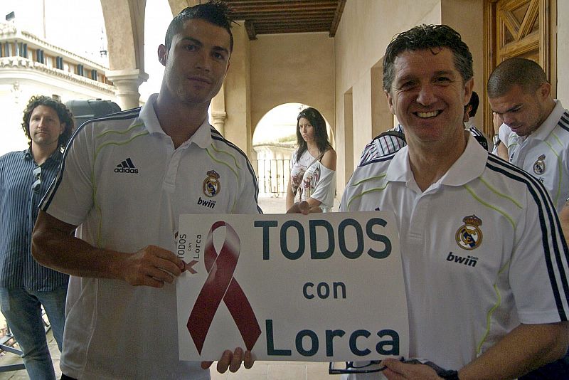 El delantero portugués del Real Madrid Cristiano Ronaldo y el delegado del equipo, el murciano Miguel Porlán Chendo, posan con un cartel de apoyo a Lorca.