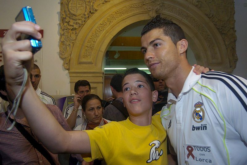 El delantero portugués del Real Madrid Cristiano Ronaldo se fotografía con un aficionado en el Ayuntamiento de Lorca.