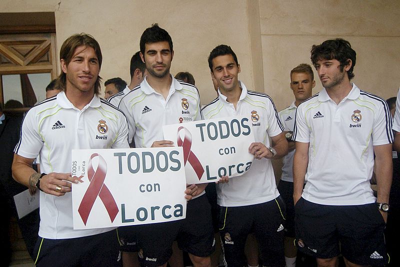 Los jugadores del Real Madrid Sergio Ramos, Raúl Albiol, Álvaro Arbeloa y Esteban Granero posan con una pancarta de apoyo a Lorca.