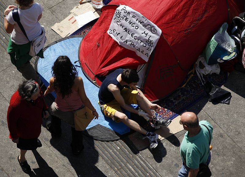 A demonstrator gets out of his tent while camping out in Madrid's Puerta del Sol during eighth day of protests