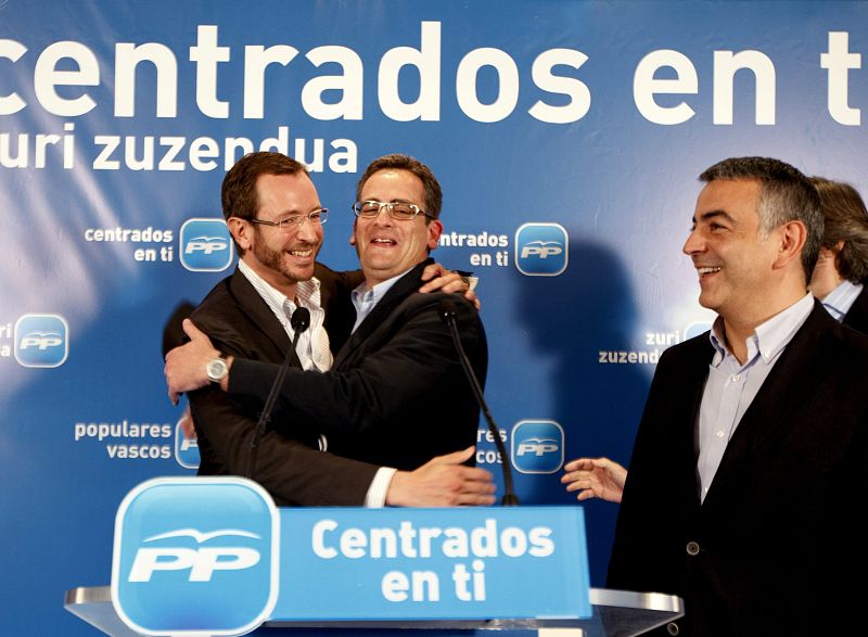 El presidente del PP del País Vasco, Antonio Basagoiti (c) se abraza con el candidato a la alcaldia de Vitoria, Javier Maroto (i), en presencia del candidato a la diputación general de Álava, Javier de Andrés (d).