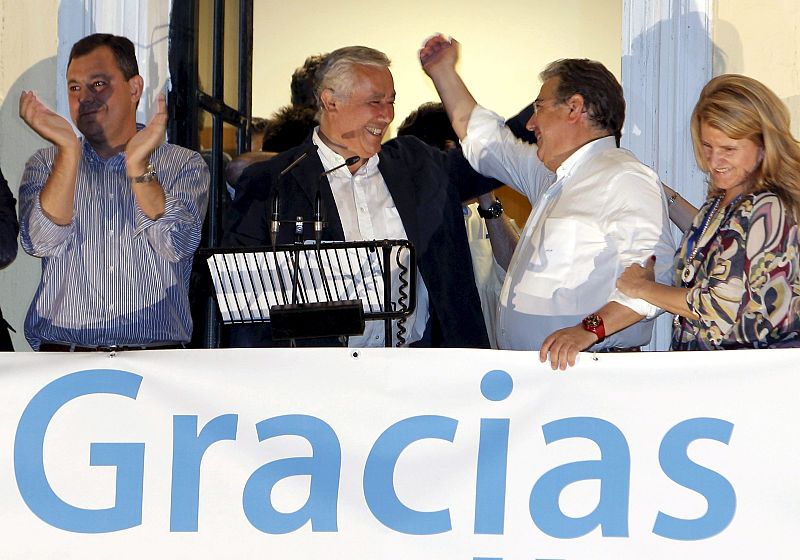 El secretario general del PP de Sevilla, Jose Luis Sanz, el presidente de este partido en Andalucía, Javier Arenas, y el candidato por Sevilla, Juan Igcnacio Zoido, y su esposa (i-d), en el balcón de la sede del PP en Sevilla.