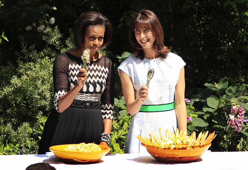 Michelle Obama (i) y Samantha Cameron (d) posan divertidas durante la barbacoa
