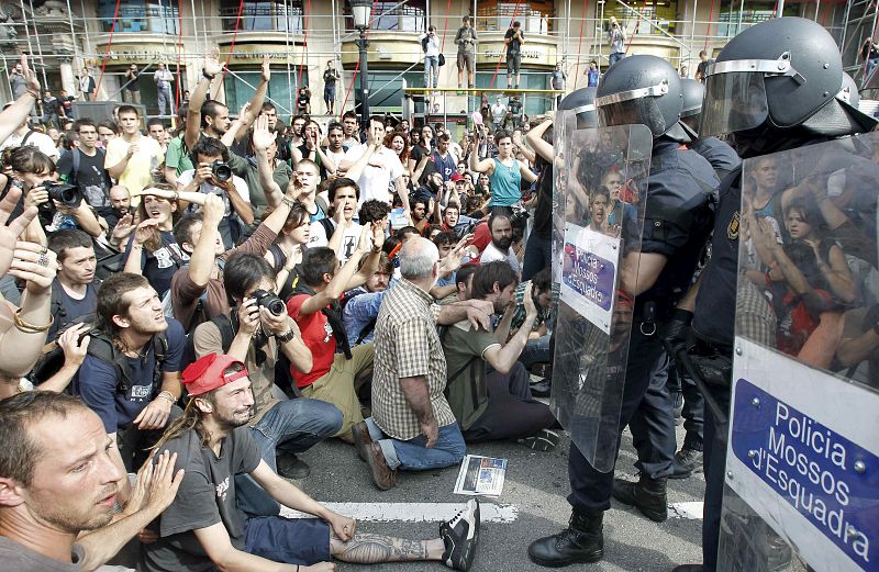Muchos jóvenes permanecen sentados ante los policías antidisturbios