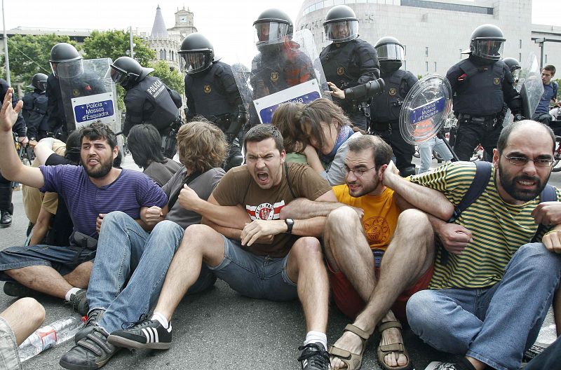 Un grupo de acampados permanecen sentados en el suelo de la plaza Cataluña