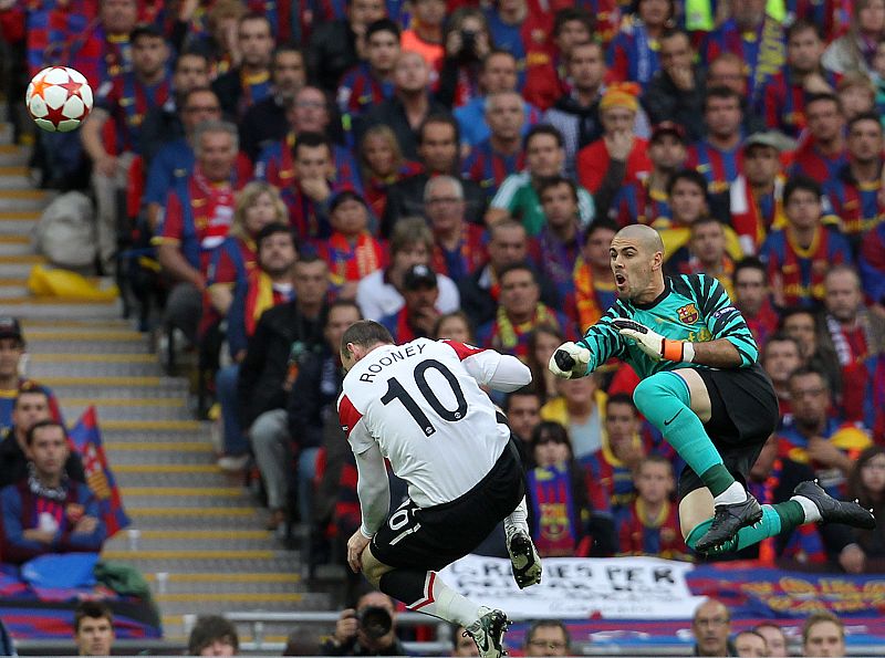 Víctor Valdés sale con fuerza para interceptar a un balón al que quería llegar el delantero inglés Rooney.