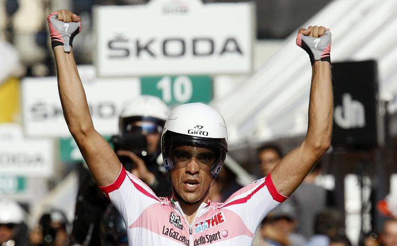 El líder del Giro entra en meta con los brazos en alto.