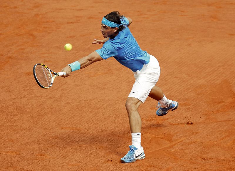Rafael Nadal se estira para responder la bola al suizo Roger Federer en la final del torneo de Roland Garros en París.