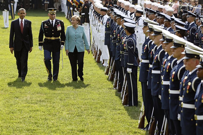 Obama y la canciller alemana pasan revista a las tropas durante la ceremonia de bienvenida celebrada en honor de Merkel en los jardines de la Casa Blanca, en Washington.