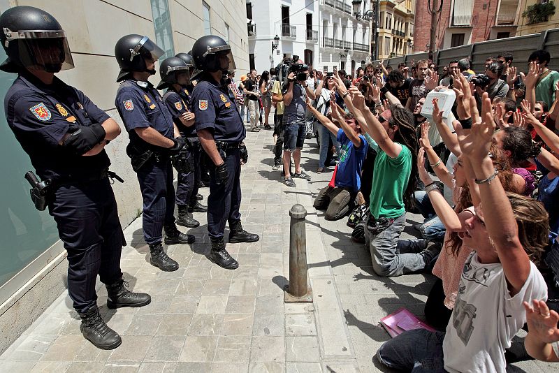 Agentes de la Policía Nacional vigilan a un grupo de manifestantes durante la protesta del movimiento 15-M