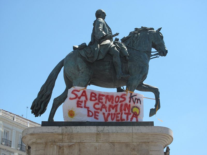 Pancarta en la estatua de Carlos III (Puerta del Sol): "Sabemos el camino de vuelta".