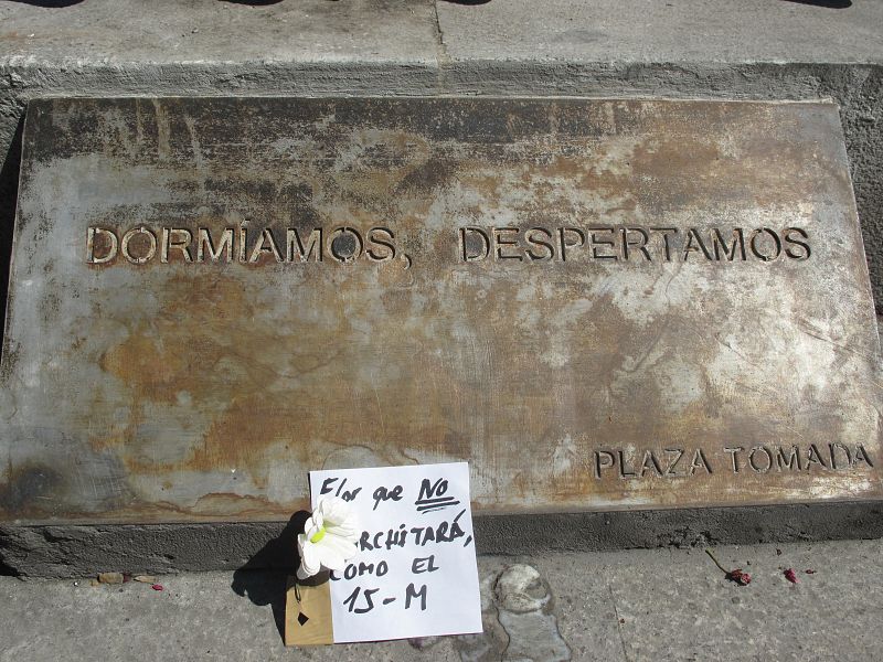 Placa colocada debajo de la estatua de Carlos III, en el centro de la Puerta del Sol: "Dormíamos, despertamos"