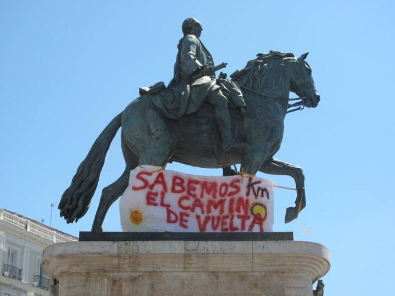 Pancarta en la estatua de Carlos III (Puerta del Sol): "Sabemos el camino de vuelta".