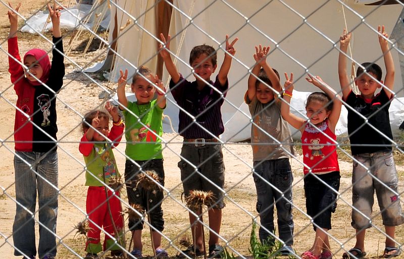 Un grupo de niños saluda desde un campo de refugiados en Turquía.
