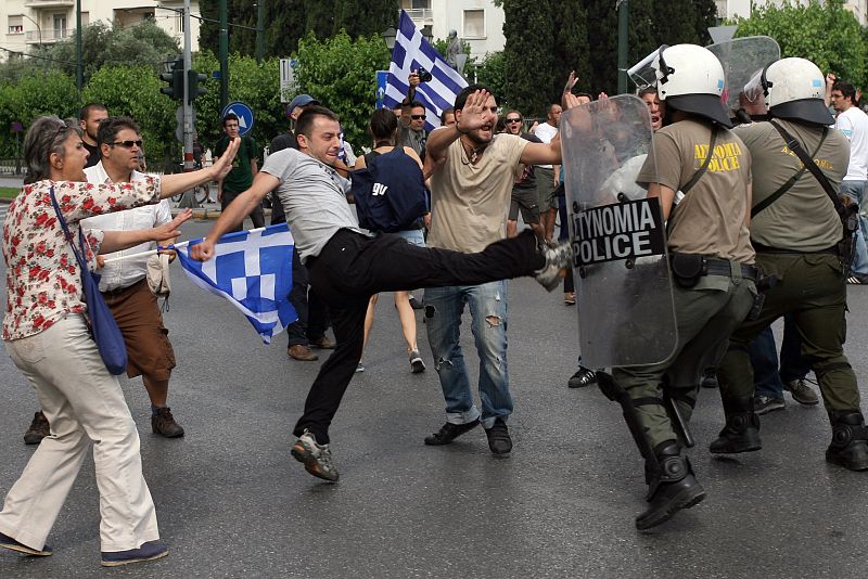 Un manifestante lanza una patada contra un policía griego