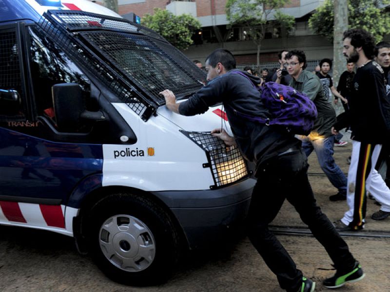 Un grupo de manifestantes intenta impedir el paso de una furgoneta de la Policía frente al Parque de la Ciutadella.