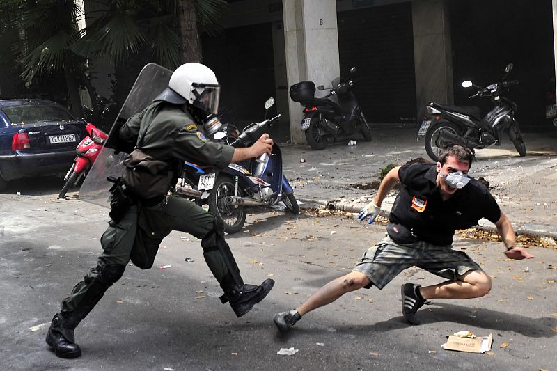 Un policía persigue a un manifestante en Atenas