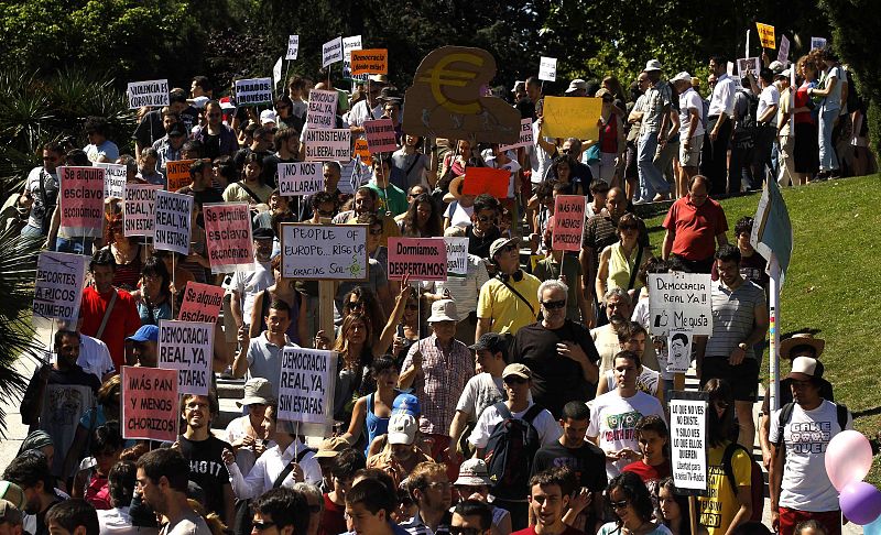 Los manifestantes muestran carteles durante su marcha hacia la Plaza de Neptuno de Madrid.