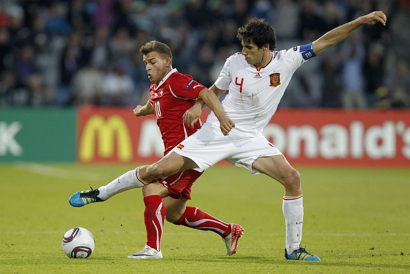 Xherdan Shaqiri (i) de Suiza lucha por el balón con Javi Martinez de España