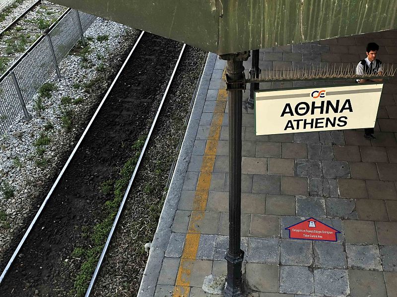 Un vigilante, la única persona cerca de las vías del tren de la estación de Atenas