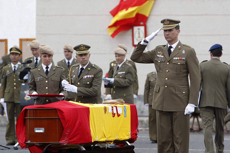 Don Felipe saluda tras imponer sobre el ataúd de la soldado, cubierto con la bandera de España, la Cruz del Mérito Militar