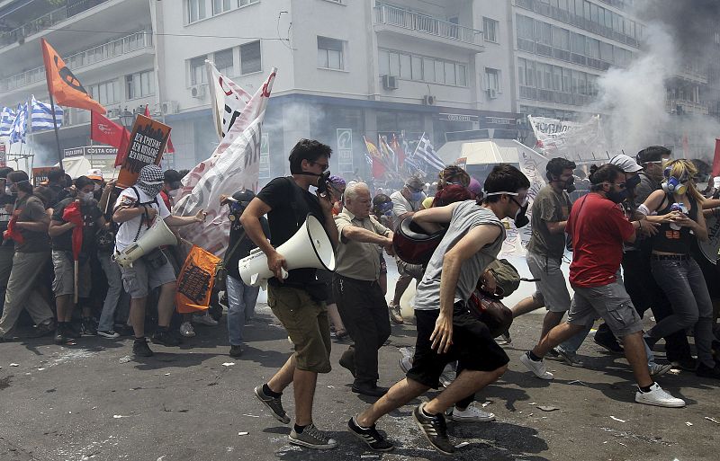 Los manifestanes llevan pancartas y un megáfono para protestar contra el nuevo plan de ajuste aprobado por el Parlamento