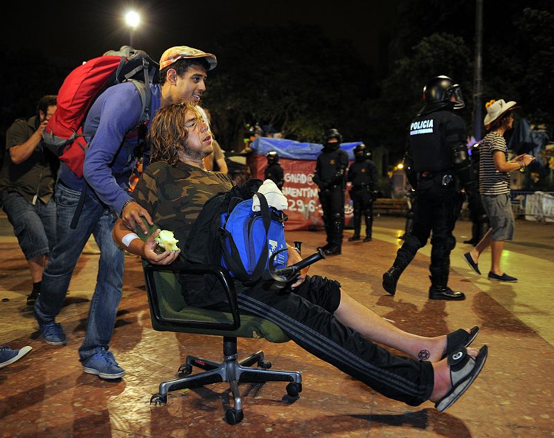 Un 'indignado' acarrea con otro empujándole en una silla de ruedas tras el ultimátum de la policía