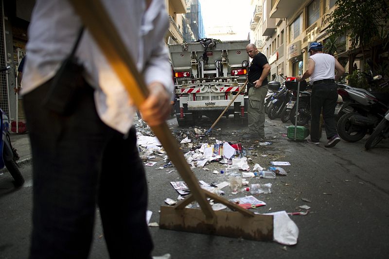 Varios operarios limpian las calles tras los fuertes enfrentamientos protagonizados ayer por la policía y los manifestantes delante del Parlamento griego en Atenas (Grecia).