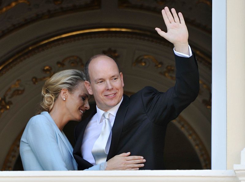 La princesa Charlene Wittstock abrazo al Príncipe Alberto de Mónaco mientras él saluda desde el balcón del Palacio Real.