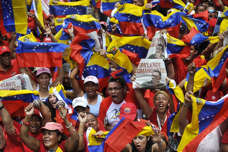 Una multitud marcha por Caracas con banderas de Venezuela y pancartas dedicadas a Chávez