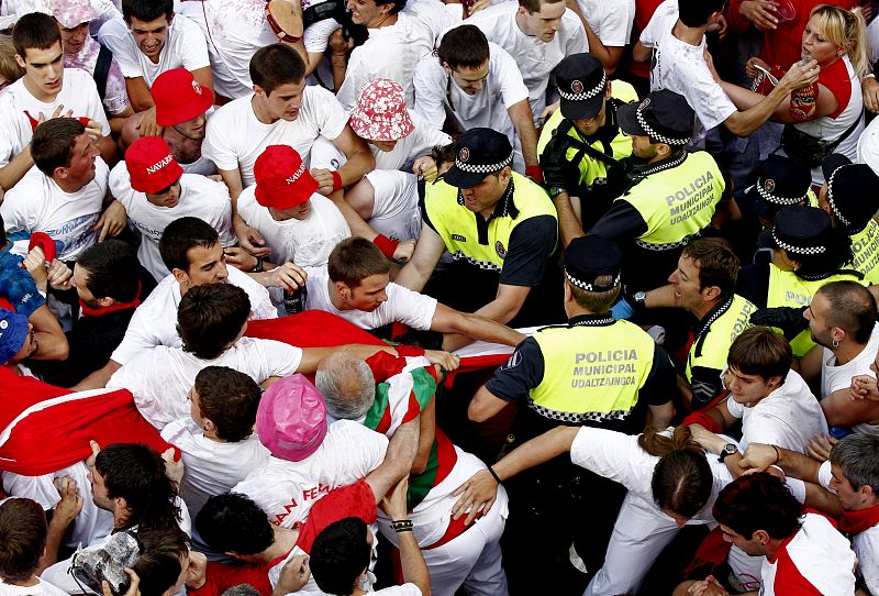 Forcejeo entre un grupo de jóvenes y agentes de la Policía Municipal que no impidieron la entrada de una ikurriña a la Plaza del Ayuntamiento de Pamplona.