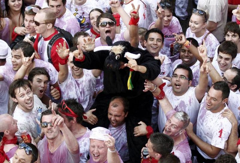 Un joven vestido de toro es subido a hombros en la Plaza del Ayuntamiento