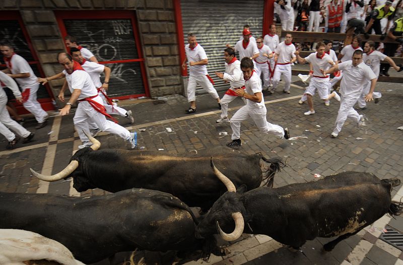 Los mozos corren junto a la manada por las calles de Pamplona