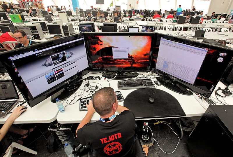 Un hombre navega con su ordenador preparado con tres pantallas de 37" que le permiten disfrutar mas intensamente de los juegos.