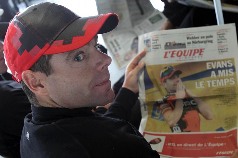 Cadel Evans lee la prensa en el aeropuerto de Grenoble donde los corredores del Tour tomaron un avión hacia París.