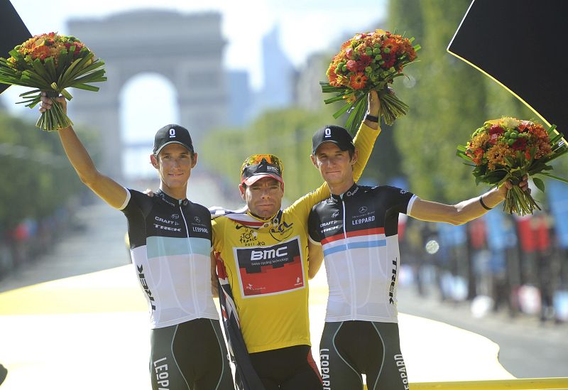 El corredor australiano del BMC, Cadel Evans, celebra en el podio su victoria en la clasificación general del Tour de Francia, junto a los hermanos luxemburgueses del Leopard-Trek, Andy, segundo, y Frank Schleck, tercero.