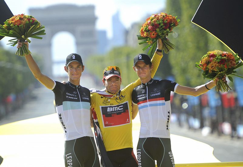 El corredor australiano del BMC, Cadel Evans, celebra en el podio su victoria en la clasificación general del Tour de Francia, junto a los hermanos luxemburgueses del Leopard-Trek, Andy, segundo, y Frank Schleck, tercero.