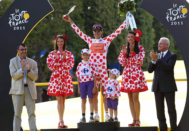 El ciclista español del Euskaltel Euskadi, Samuel Sánchez, celebra junto a sus hijos y el director de la Vuelta a España, Javier Guillén, quien le colocó el maillot de lunares, el triunfo en la clasificación de la montaña en los Campos Elíseos de Par